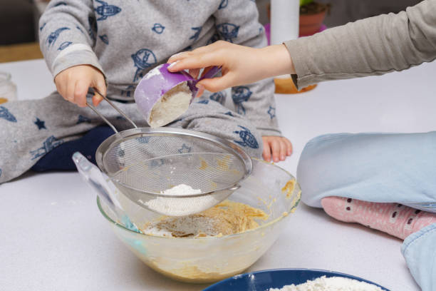 дети смешивают ингредиенты для приготовления торта - cake making mixing eggs стоковые фото и изображения