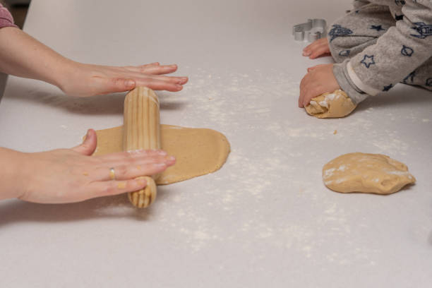 istock woman kneading cookie dough with a wooden rolling pin 1457297839