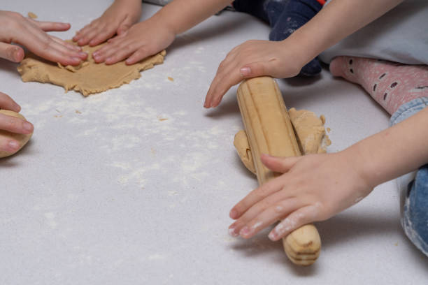 istock child kneading cookie dough with a wooden rolling pin 1457297887