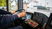 Bus driver holding steering wheel, close up on hands