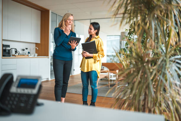 istock Asian and Caucasian  Female Office Employees Discussing Work Using Tablet 1457298402