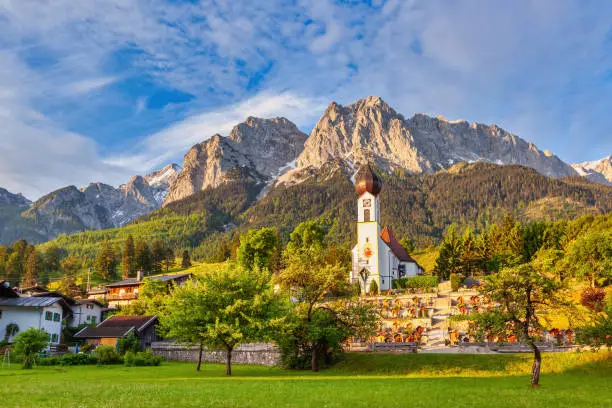 Garmisch Partenkirchen Germany, Zugspitze peak and Alps mountain range with small church in Grainau village