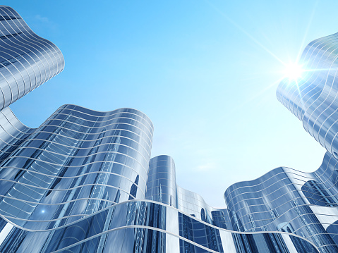 Low wide-angle view looking up to modern skyscrapers in business district on a beautiful sunny day with blue sky