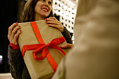 Man surprising woman with a gift while celebrating Valentines