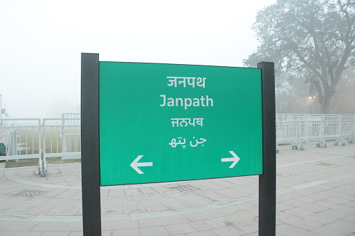 Central Delhi has unique street signs for road names. This photo shows the ubiquitous green direction board for Janpath lane street sign Delhi,India written in English,Hindi,Punjabi and Urdu - image