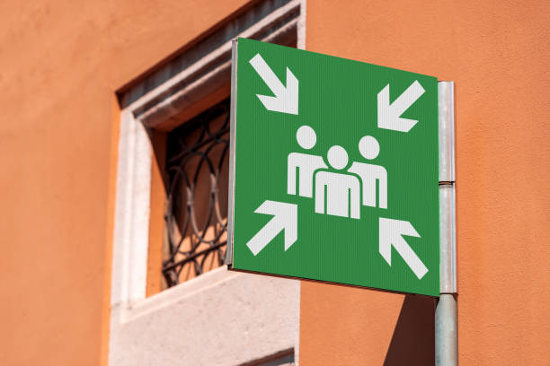 istock Emergency Assembly Point - Green Sign in a City 1457307210