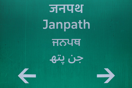 Central Delhi has unique street signs for road names. This photo shows the ubiquitous green direction board for Janpath lane street sign Delhi,India written in English,Hindi,Punjabi and Urdu - image