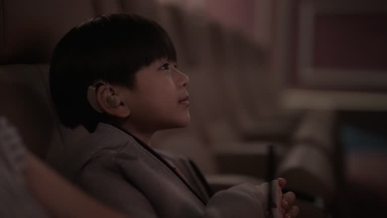 Close-up of Young child is watching a movie while eating popcorn.