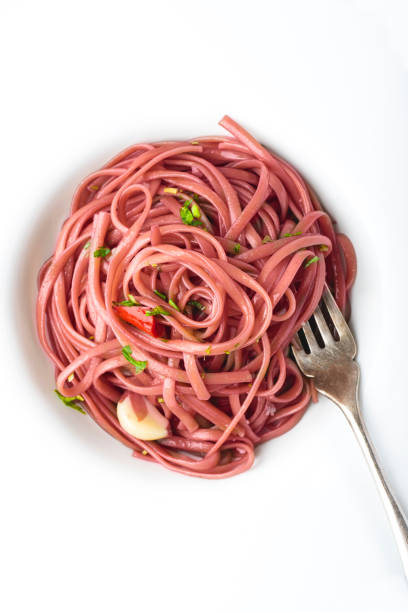 spaghetti pasta stewed on red wine with bay leaves, garlic and parsley, white table. unusual, regional and simple italian pasta recipes (original pasta with barolo wine). close-up - bay leaf healthy eating food and drink red imagens e fotografias de stock