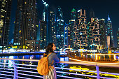 Woman walking in Dubai Marina at sunset