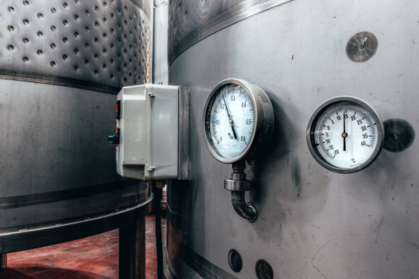 istock Wine fermentation tanks. Manometers on steel cylinder storages. 1457311145