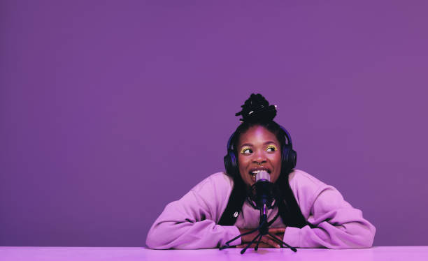 istock Female podcaster speaking into a microphone 1457313099