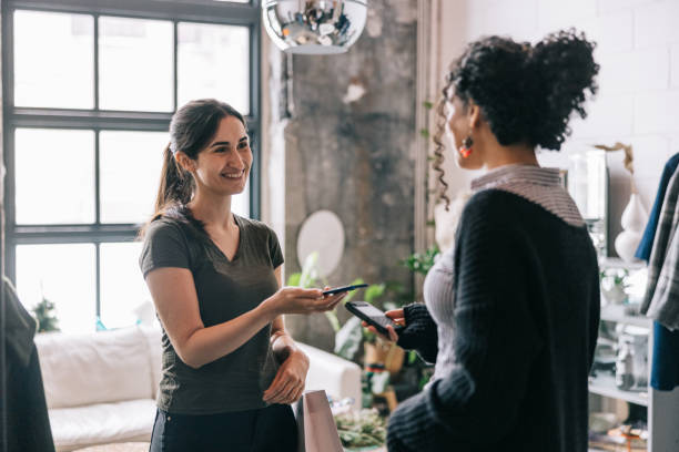 istock Latin woman making a mobile payment in modern boutique 1457314887