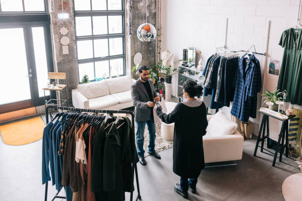 istock Indian man making a mobile payment in small business boutique 1457314909