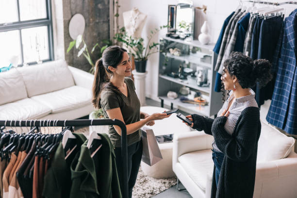 istock Latin woman making a mobile payment in modern boutique 1457314928