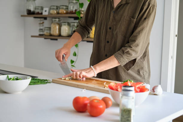 istock Unrecognizable asian young man cutting garlic. 1457316432