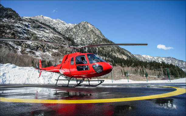 Red helicopter at the wet helipad in the mountains