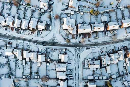 Wide angle top down aerial view of a typical UK housing estate covered in winter snow. Staffordshire, England, UK.