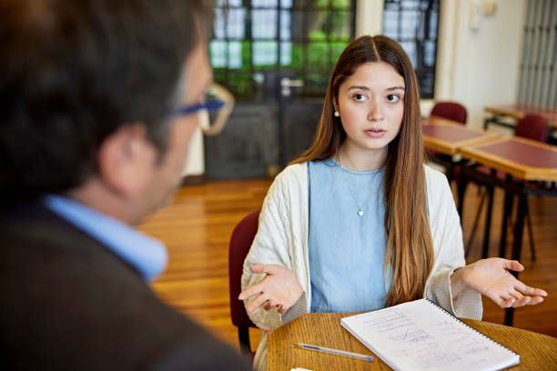 istock Confused college student meeting with instructor 1457321793