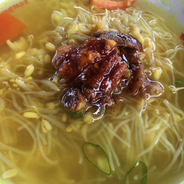istock Chicken yellow colored soup with noodle and rice called soto 1457324204