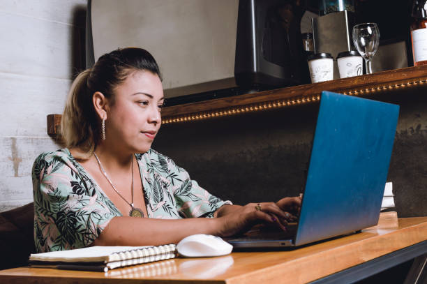 young latina freelancer with her computer using a cafeteria as her office stock photo