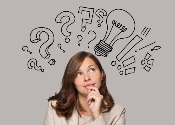 istock Brunette woman and light bulbs and question marks above her head. Idea, brainstorming, thinking concept 1457326339