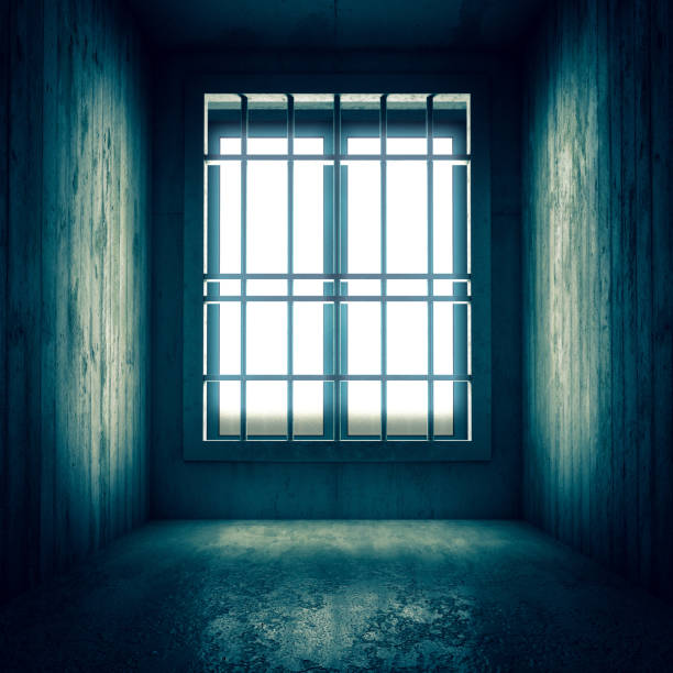 istock concrete prison cell interior and bars at bright window. 1457326444