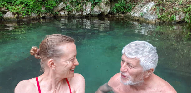 пожилая пара наслаждается природным горячим спа-центром - mobilestock freedom enjoyment blue стоковые фото и изображения
