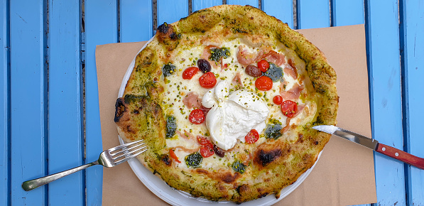 Directly above shot of whole wheat vegi pizza with cherry tomatoes, pistachio and mozzarella