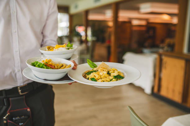 istock Waiter carrying plates with ravioli dish and salad 1457328739