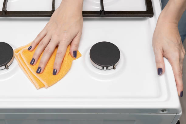 istock man wiping a gas stove with a rag 1457329956