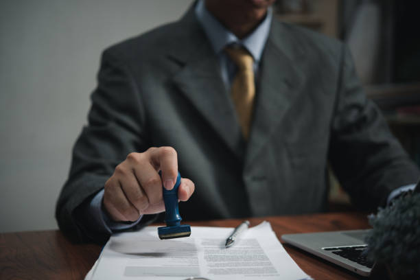 istock Signing approval record documents stamp confirmation occupation signature. businessman hand stamping finance paper work concept. 1457332095