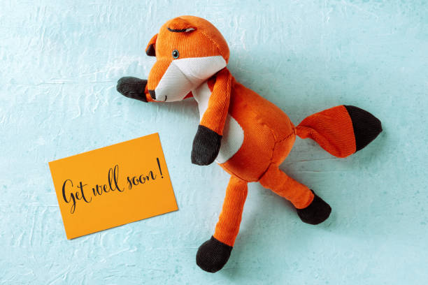 istock Get Well Soon greeting card with a toy fox, orange paper 1457335540