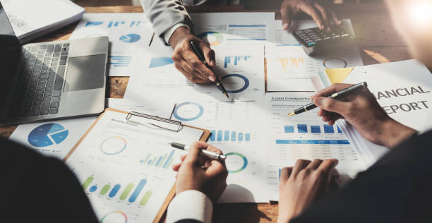 istock Business People Meeting using laptop computer,calculator,notebook,stock market chart paper for analysis Plans to improve quality next month. Conference Discussion Corporate Concept 1457336879