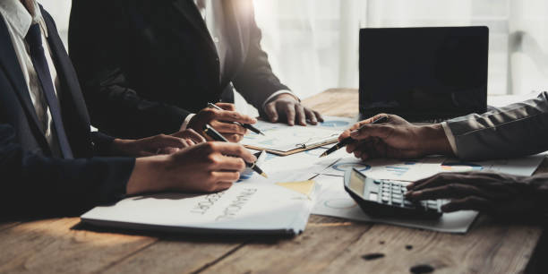 istock Business People Meeting using laptop computer,calculator,notebook,stock market chart paper for analysis Plans to improve quality next month. Conference Discussion Corporate Concept 1457336923