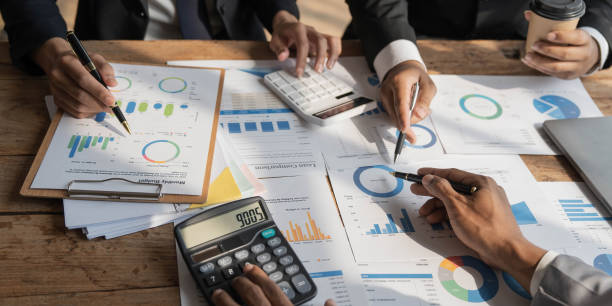 istock Business People Meeting using laptop computer,calculator,notebook,stock market chart paper for analysis Plans to improve quality next month. Conference Discussion Corporate Concept 1457337086