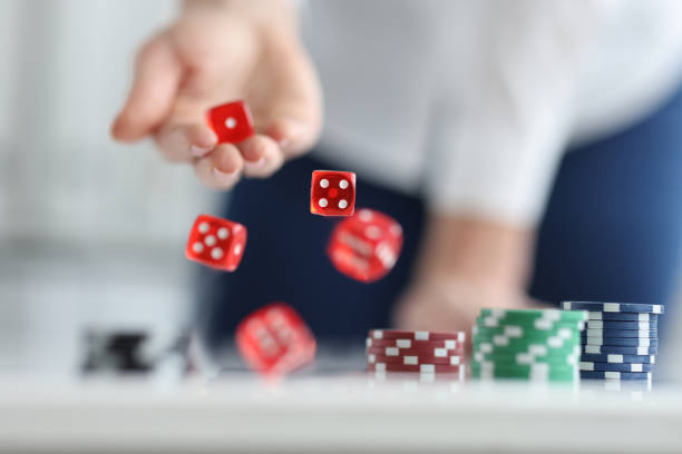 istock Player rolls dice on poker table closeup 1457337715