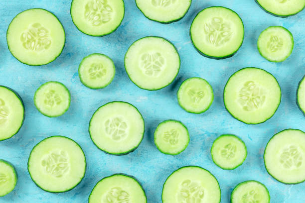 istock Fresh cucumber slices on a blue background, overhead flat lay shot 1457339403