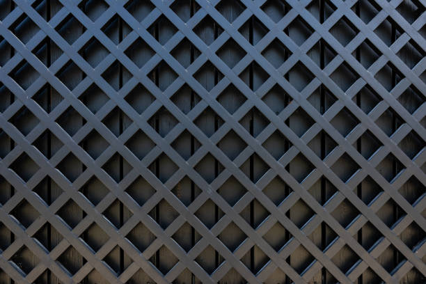 un frammento di una recinzione di legno fatta di tavole nere dipinte. reticolo diagonale in legno - decorazione a canestro foto e immagini stock
