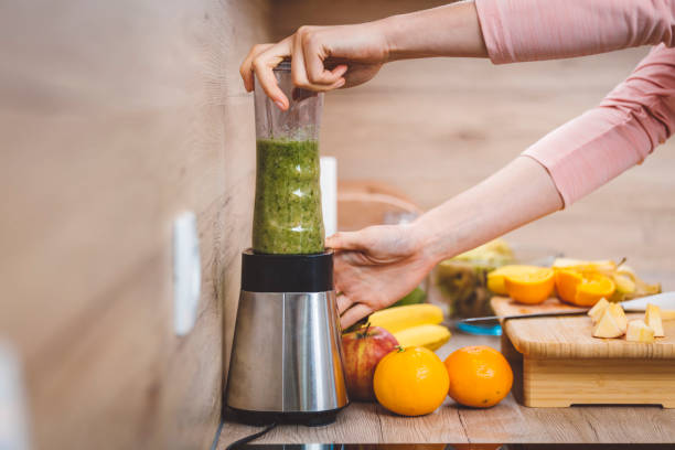 istock Young woman making fruits smoothies with blender 1457344809