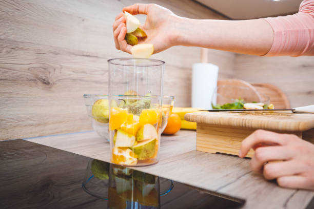 istock Young woman making fruits smoothies with blender 1457344893