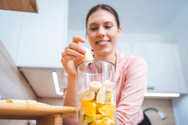 istock Young woman making fruits smoothies with blender 1457344924
