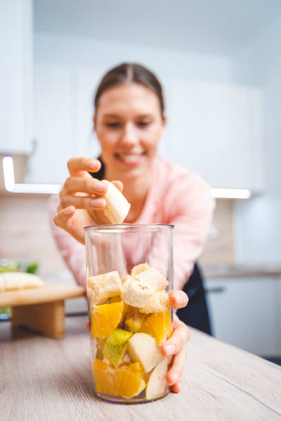istock Young woman making fruits smoothies with blender 1457344935