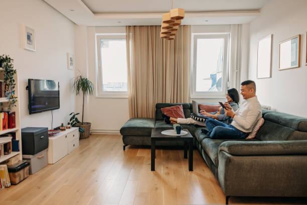 istock A young couple on a sofa, sitting and enjoying modern technology. 1457345100