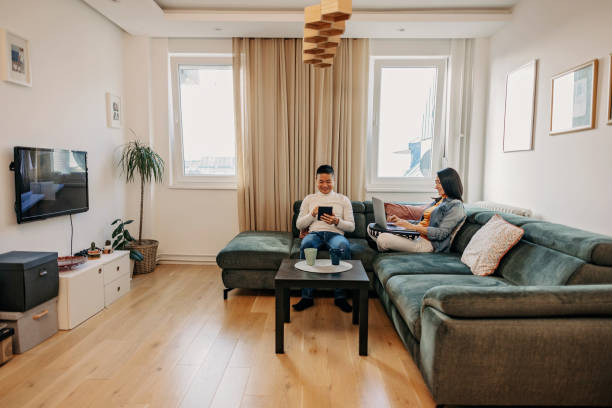 istock A young couple on a sofa, sitting and enjoying modern technology. 1457345131