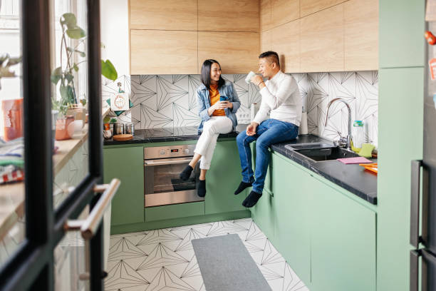 istock Young couple talking about things, drinking tea and laughing. 1457345700