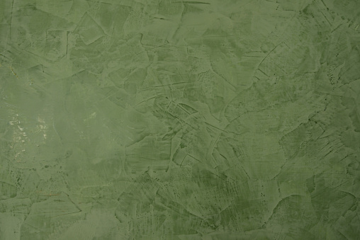 Dark green venetian plaster. Venetian stucco texture. Plastering wall. Decorative plaster background
