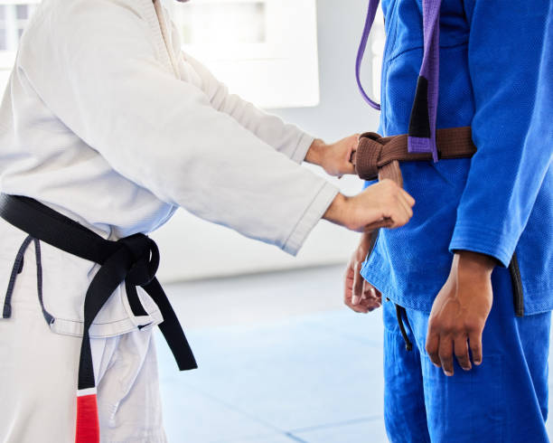 istock Belt, student and coach at karate training ready while learning, fitness and motivation in a class. Cardio, health and taekwondo teacher helping a man prepare for martial arts fight at a club 1457346895
