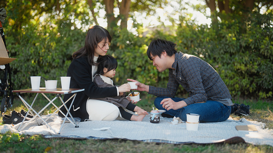 A family is enjoying having a picnic together in nature.