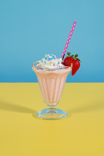 delicious strawberry ice cream sundae on vintage blue and yellow background